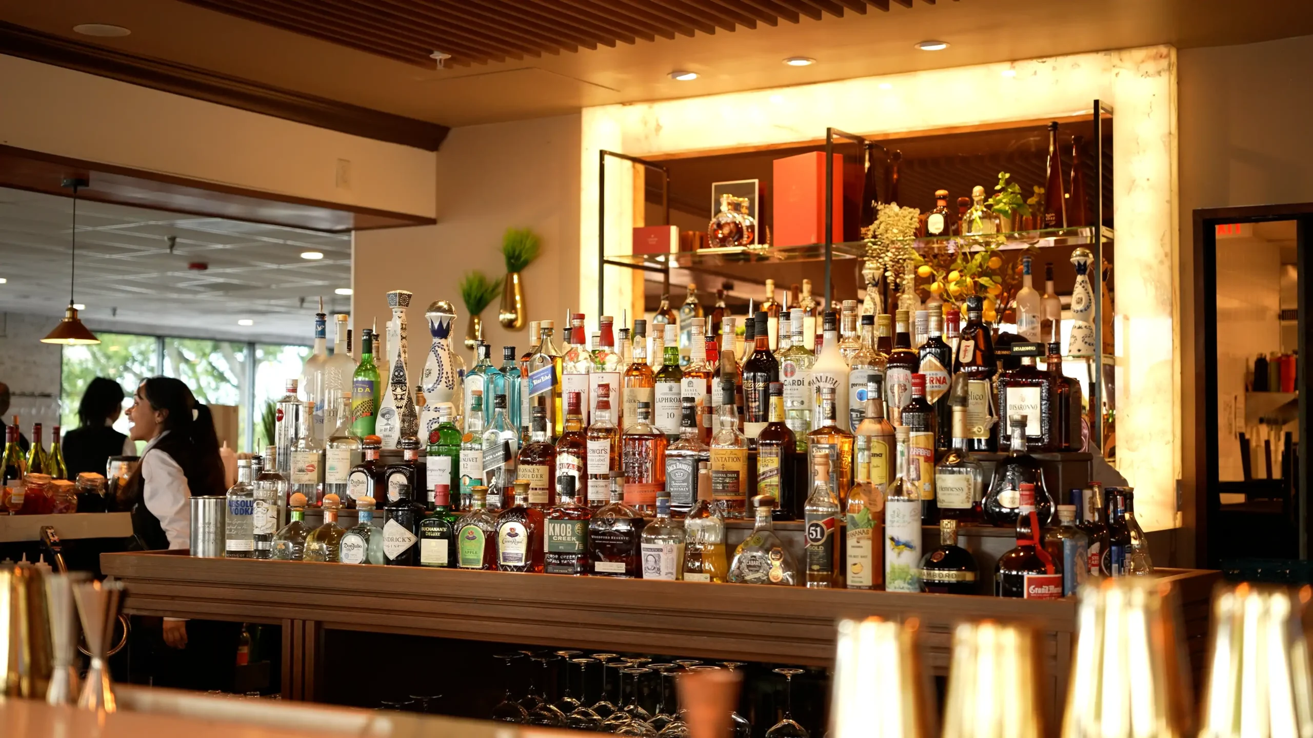The bar at Adega Gaucha Orlando with a backlit wall of spirits