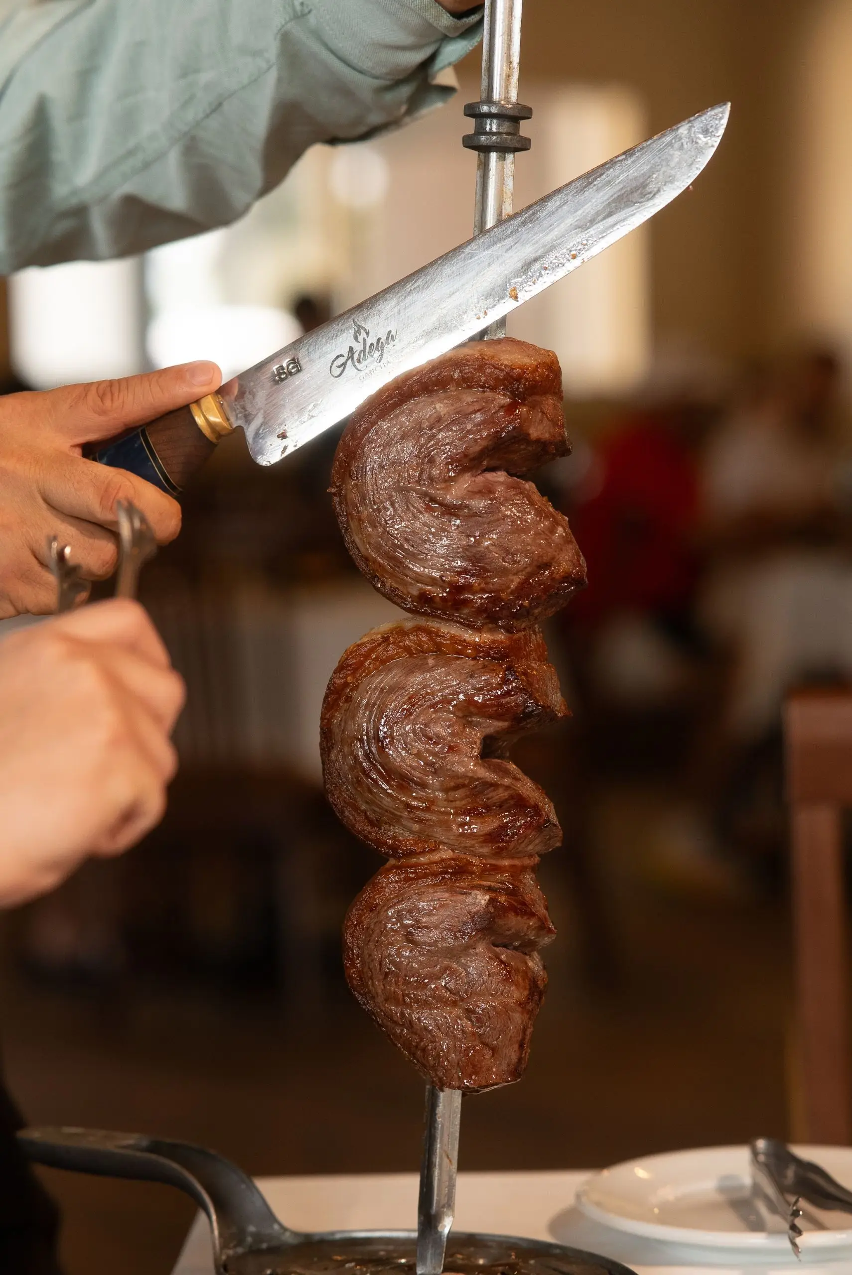 A gaucho carving fire-roasted beef from the skewer at brunch