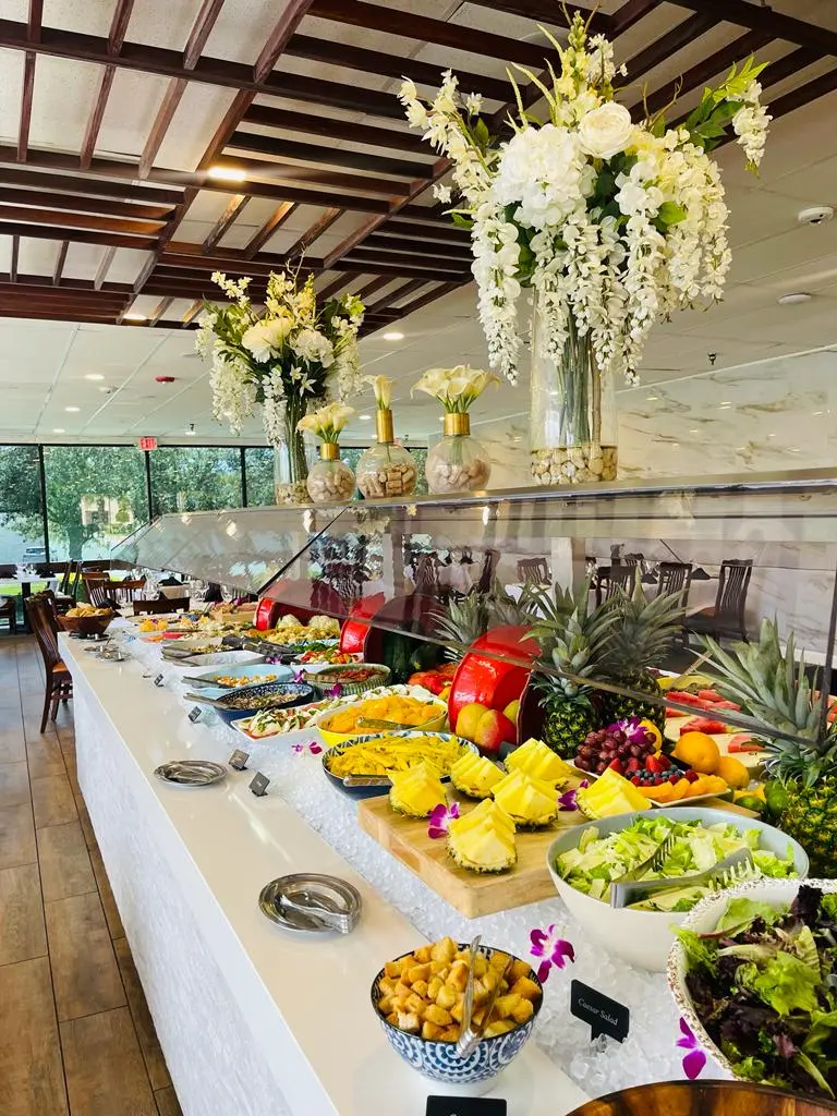 The Gourmet Table at Adega Gaucha Orlando with salads, fresh fruit, pineapple and white orchids